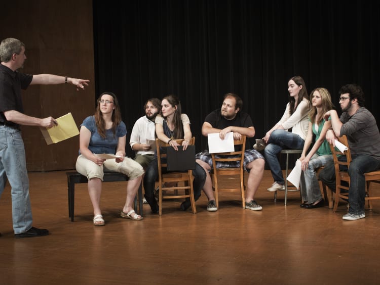 Students engage in a group activity in a theatre class setting