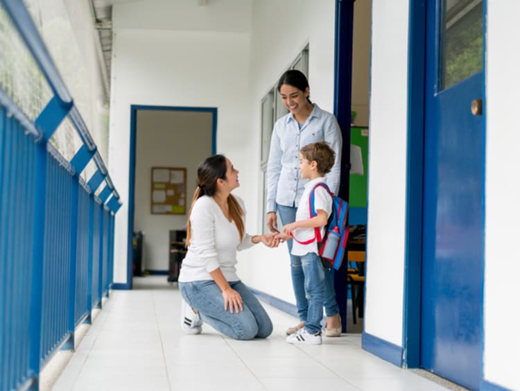 teacher talking with a student and his mother at school