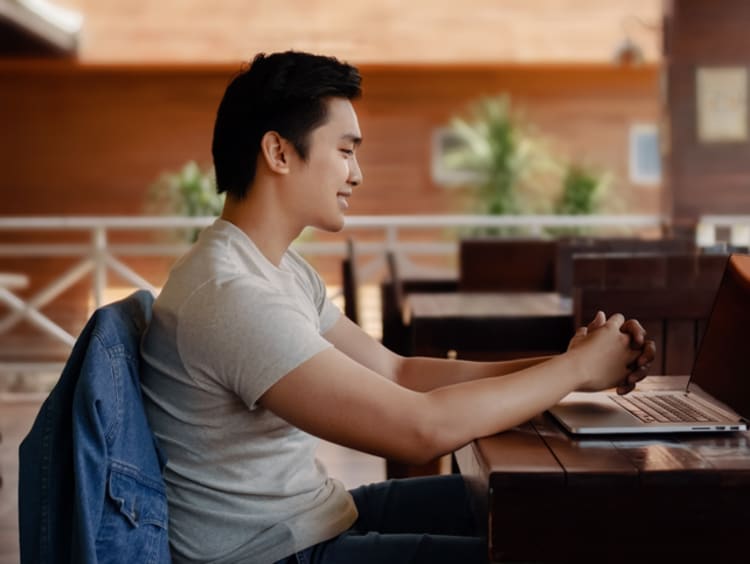 a high school student sitting at a desk attending class online