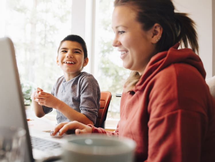 a student working on schoolwork at home with his mother