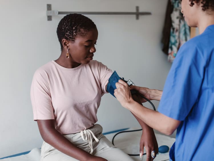 a nurse taking the blood pressure of a patient