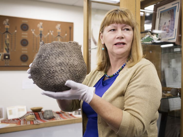 Woman holding a woven basket in museum