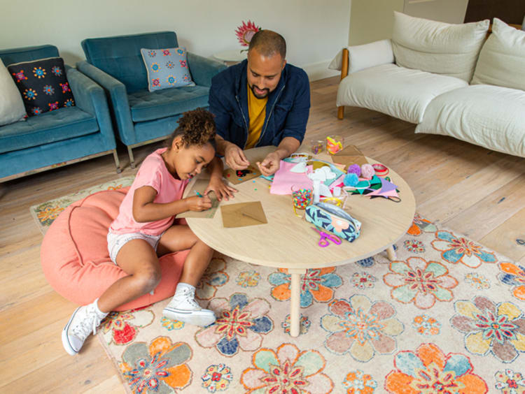 a child and her father doing crafts together