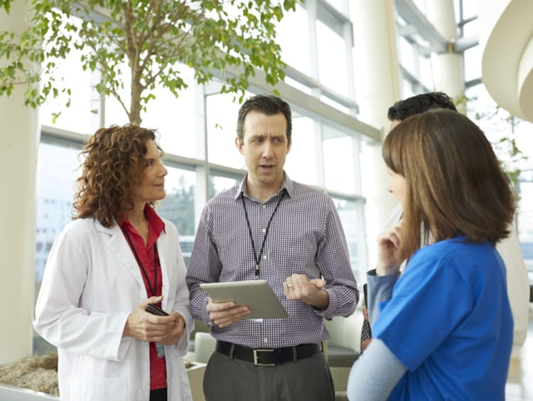 male health care administrator speaking with employees