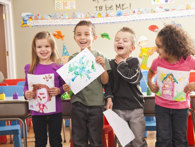 preschool children displaying their artwork