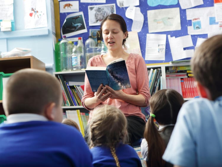 a teacher reading to elementary students