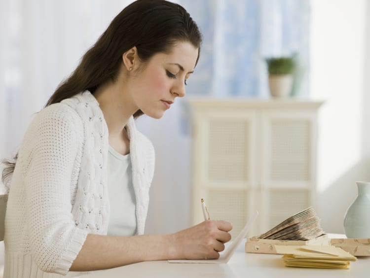 a woman writing a thank you note