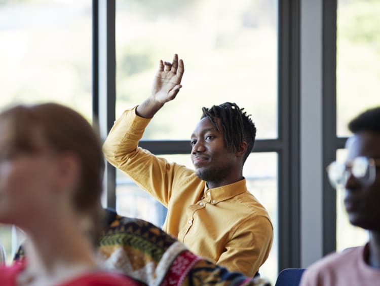 college student raising his hand in class