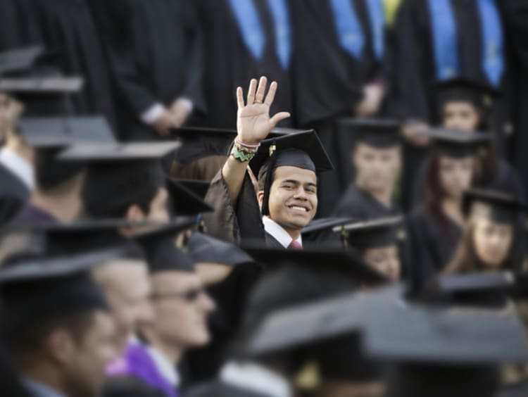 college student waving at graduation