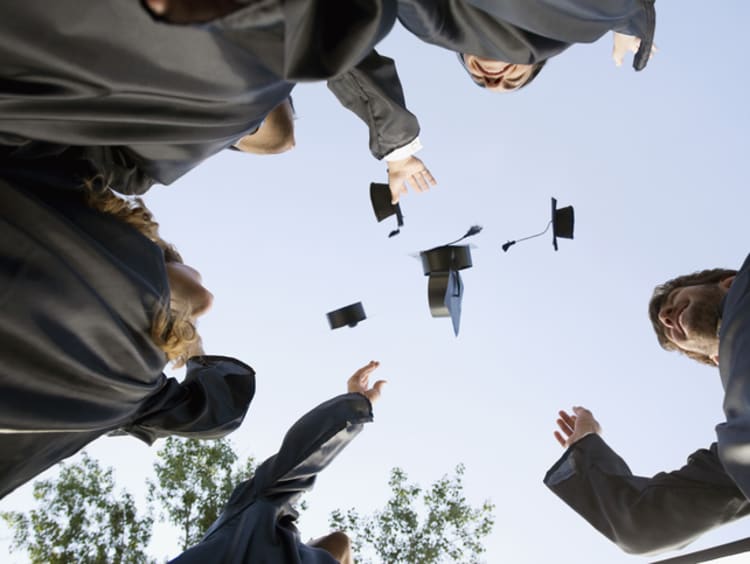 college graduates throwing caps