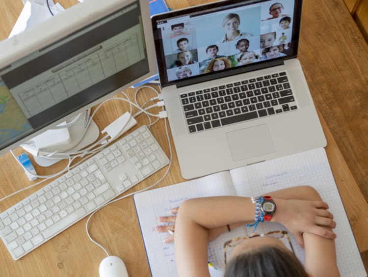 student attending class through a video call on a computer