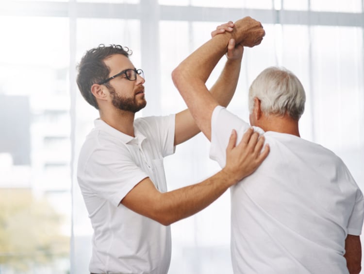 physical therapist helping an elderly patient