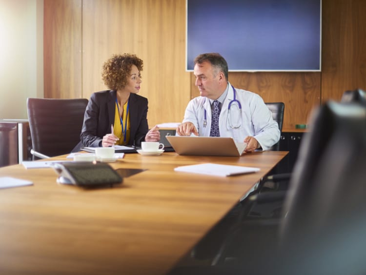 healthcare professional working with a colleague in a meeting room