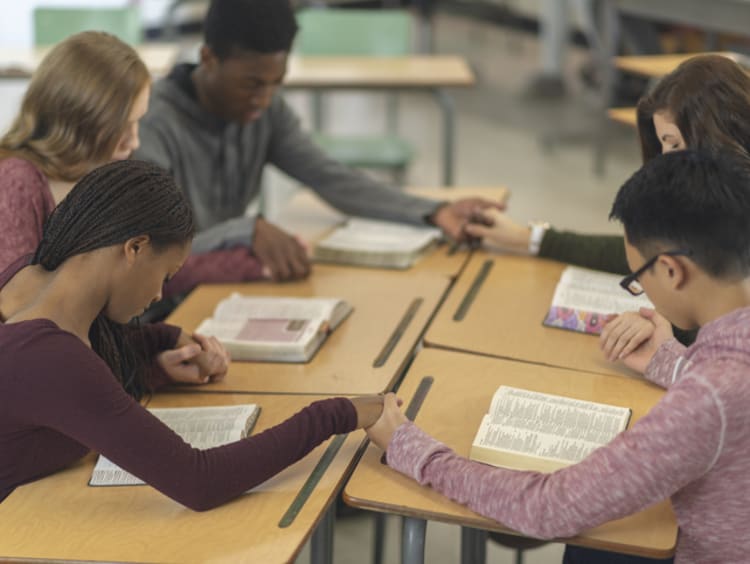 students praying in school