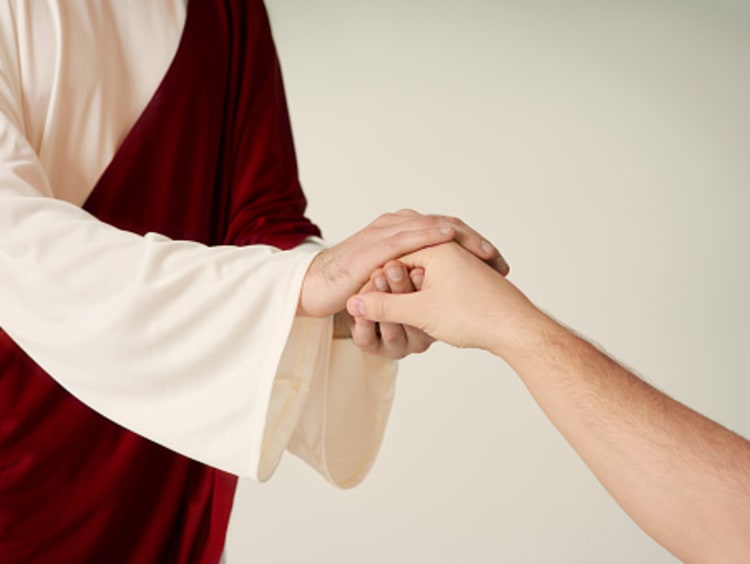 Man in a white long robe with a red sash holds another's outstretched hand