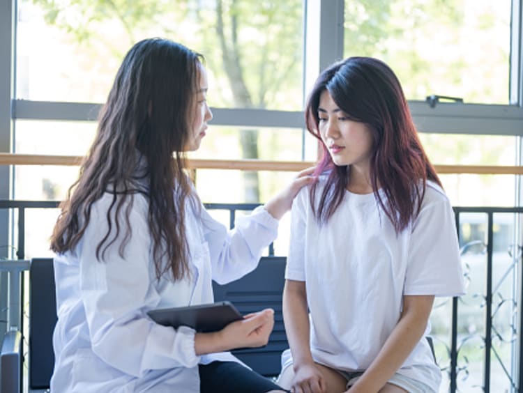 Two women, a therapist and a young girl talking.