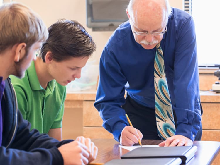 Male teacher providing effective and positive feedback to male students in class