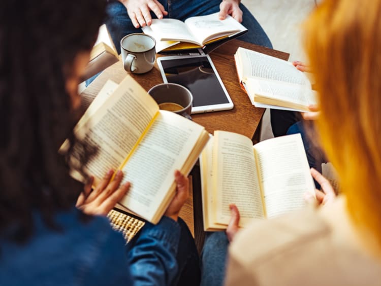 Students reading books for their book reviews 