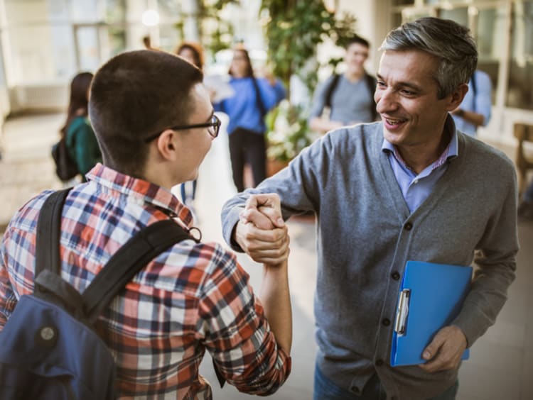 male school principal greeting student