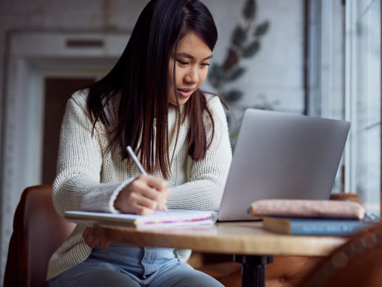 liberal arts degree student taking notes at a laptop