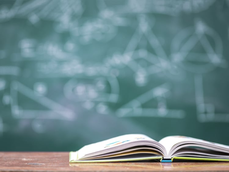 A book in front of a chalkboard 