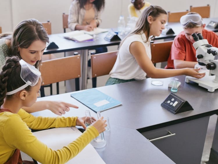 Science class teacher helping student in classroom