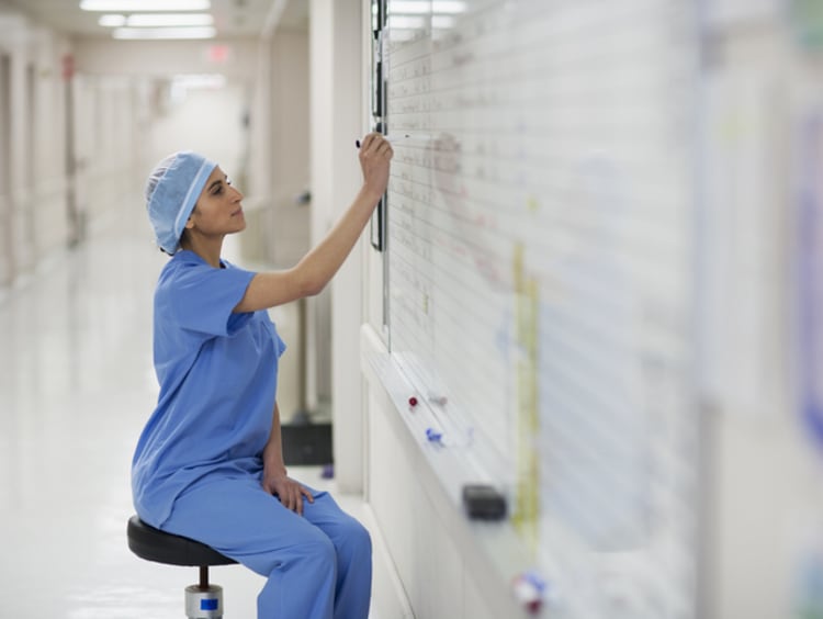 nurse writing on whiteboard in hospital