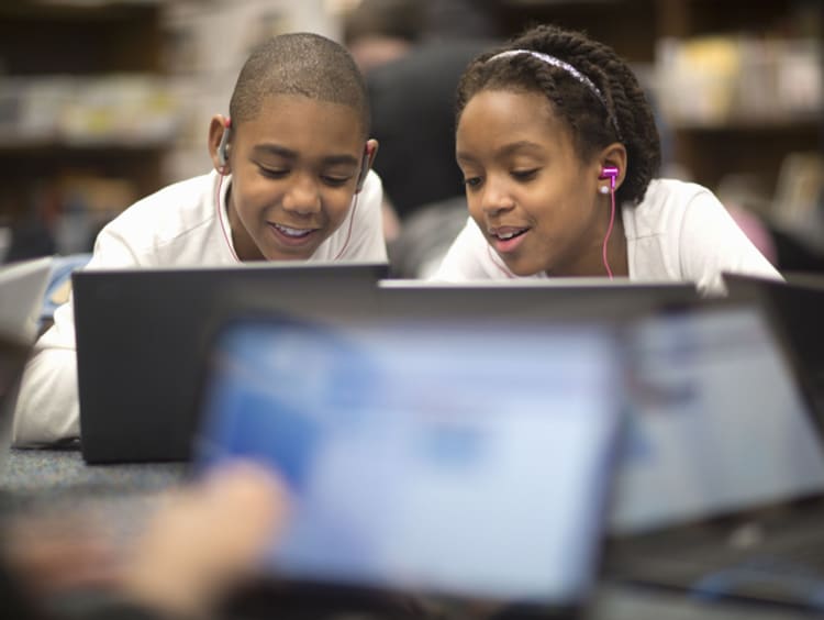 Young students helping each other learn in class