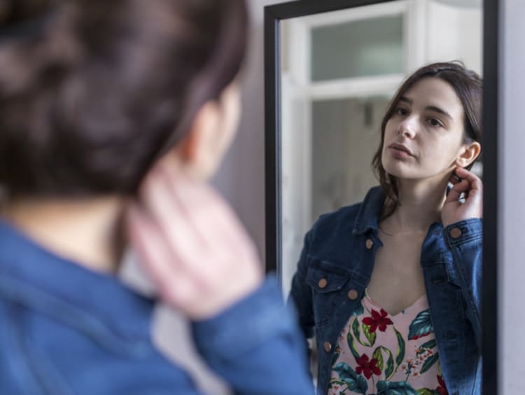 young woman looking in the mirror