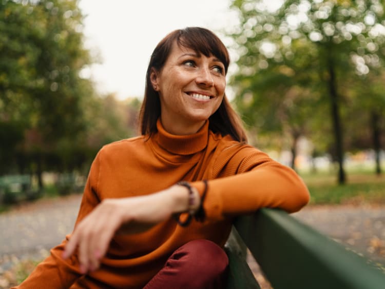 A woman on a park bench welcoming a new season