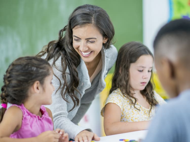 Smiling female teacher helping students