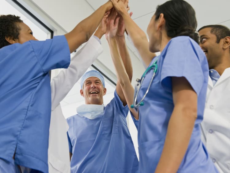 Doctors holding hands together - stock photo