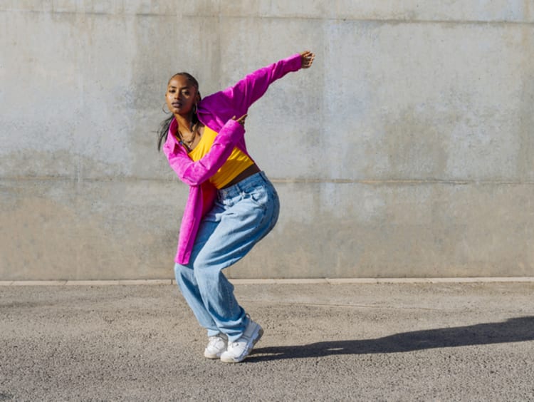 Woman breakdancing in front of wall - stock photo