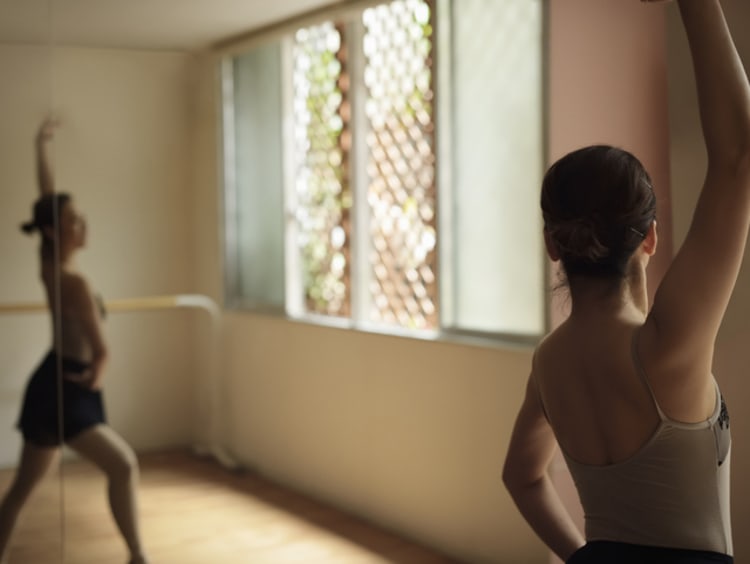 Ballerina exercising in studio - stock photo