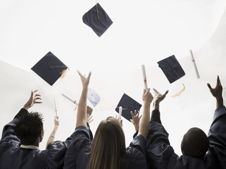 Three graduates throwing up their motarboards