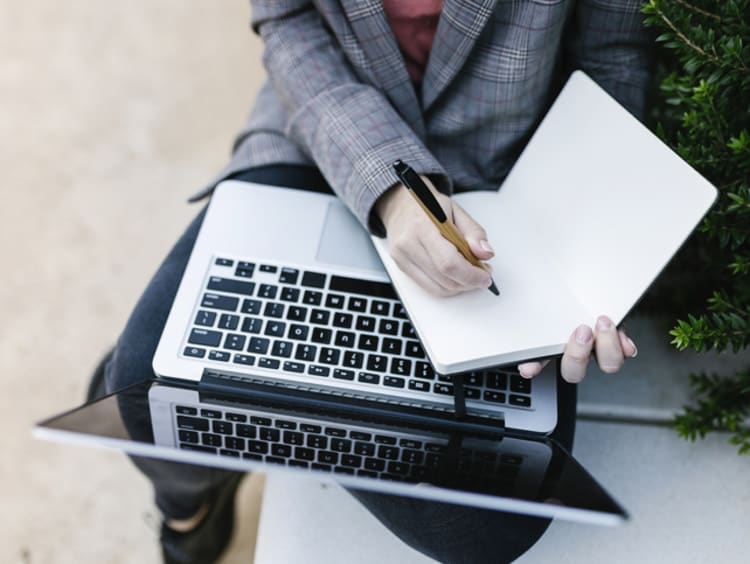 Journalist with a laptop and notepad out