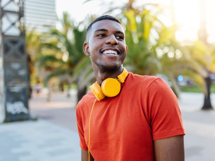 Happy and smiling male college student walking outside on campus