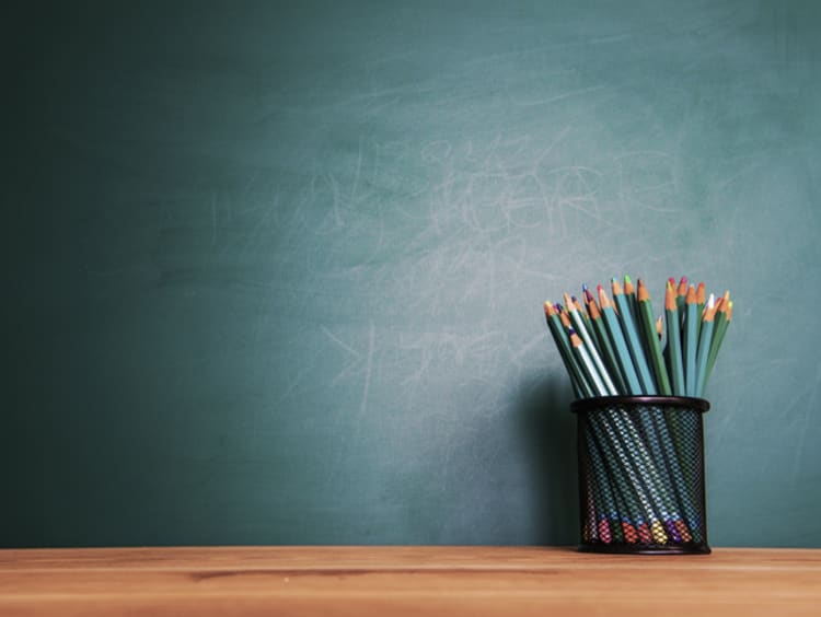 blank chalkboard and cup full of colored pencils