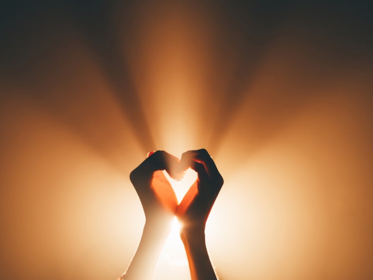 A symbolic image of faith, love and platonic pleasures. Hands forming a heart shape - stock photo