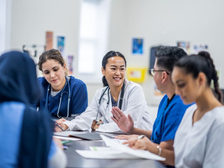 Team of nurses sitting at a table talking