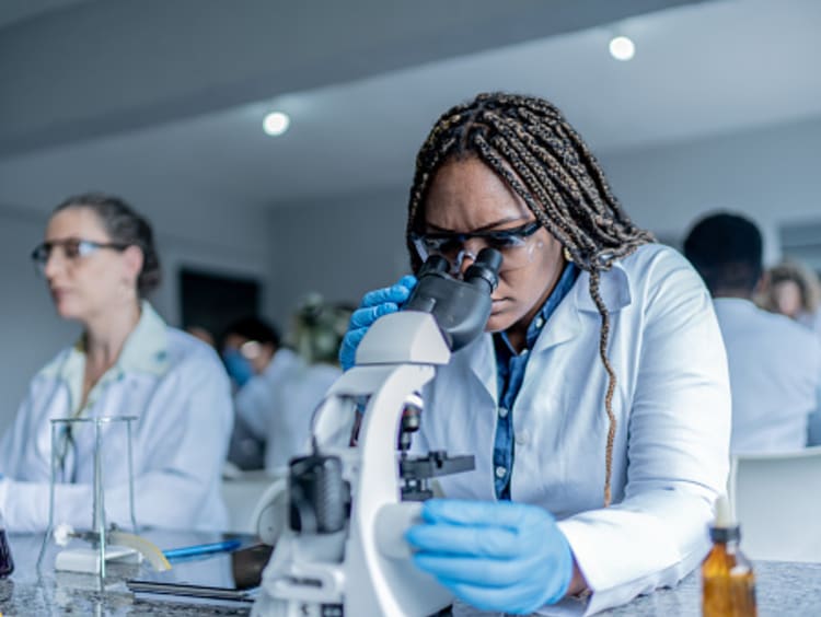 girl in class looking in microscope