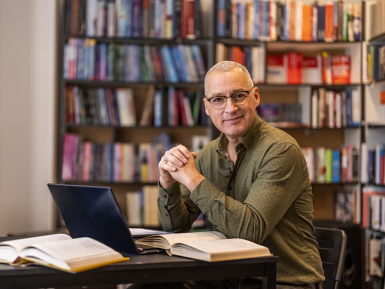 Male doctoral student studying in library