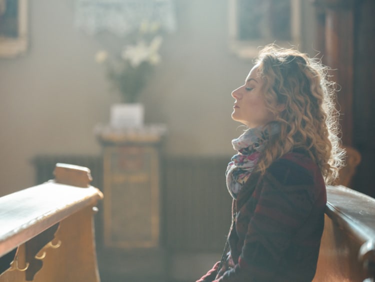 Woman breathing deeply in church.