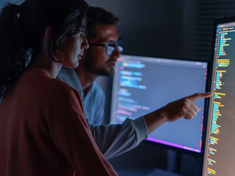 two people working at computer screens