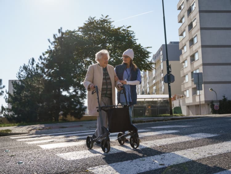 girl helping older woman across the street