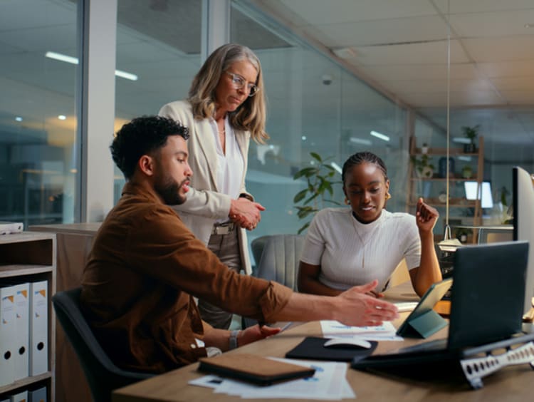 3 writers working on a project at a desk