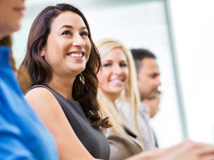 Group of adult doctoral students sit in a row