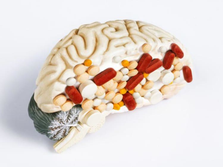 Half a model brain with pills stuck on it to resemble addiction