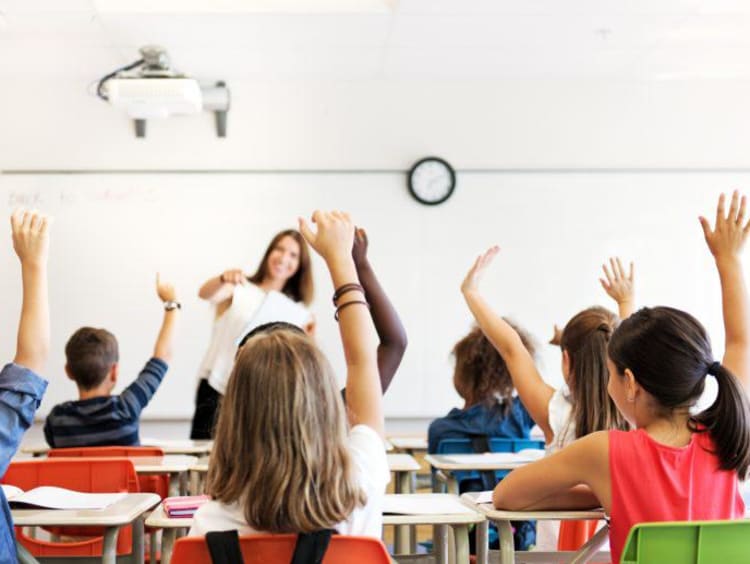 Young students raising their hands