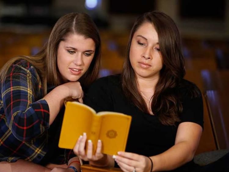 Two young women reading the Bible together